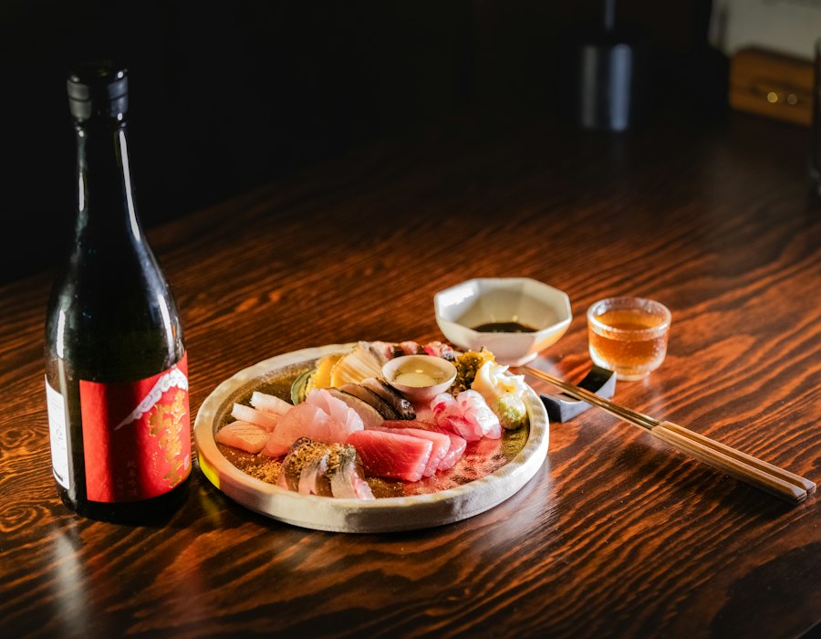 刺身の盛り合わせと、冷えた日本酒の瓶