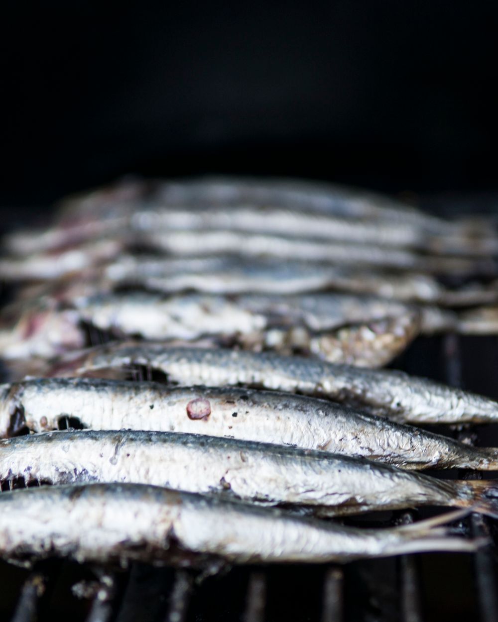 炭火で皮目を焼いた秋刀魚を、すだちと大根おろしを添えて皿に盛りつけたところ