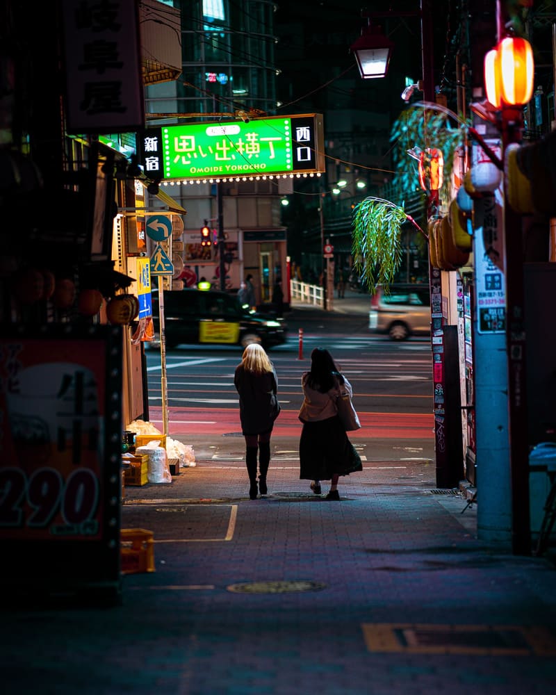 夜の路地を歩いていく、後ろ姿の2人