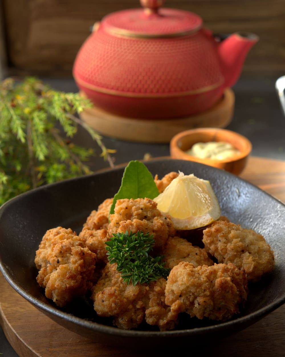 黒い鉢に盛った唐揚げと、添えられたレモン
