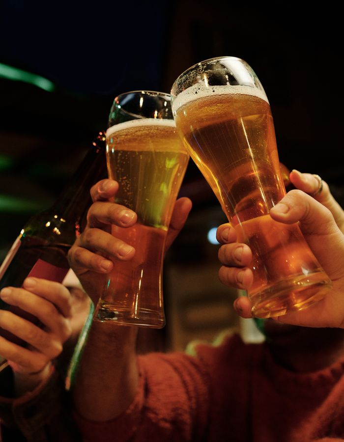 乾杯する、泡のたった生ビールのグラス