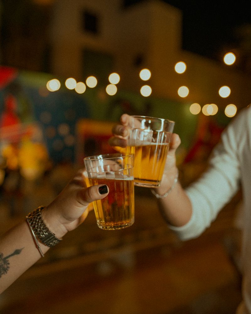夜の灯りの下でビールを合わせる週末の客席