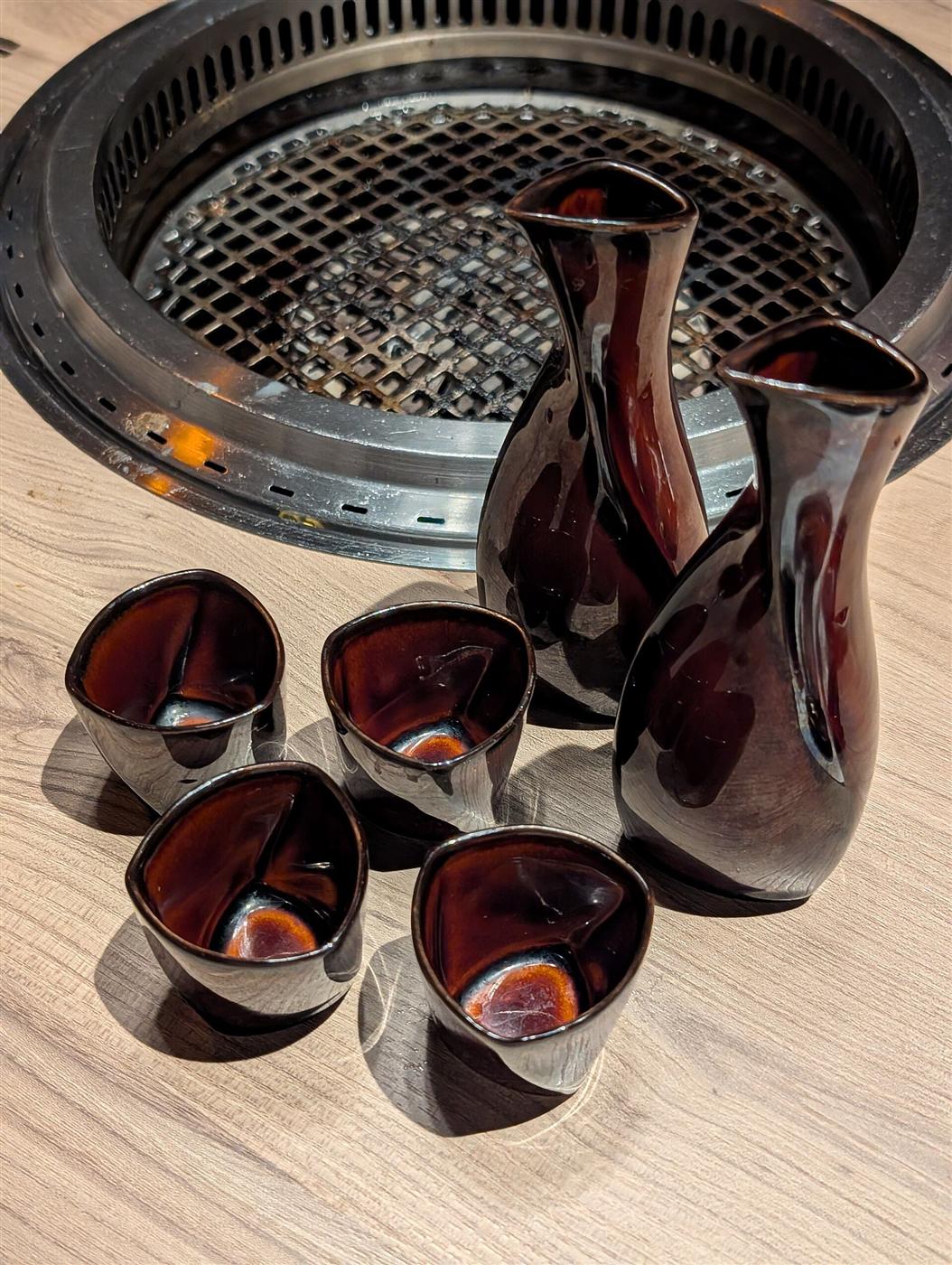 ロースターのそばに並ぶ、深い赤茶色の徳利と盃