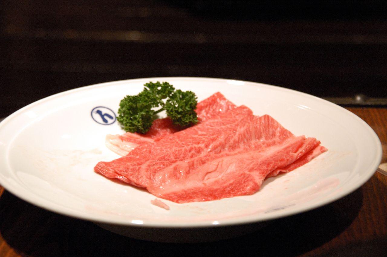 白い皿に盛られた、黒毛和牛の薄切り